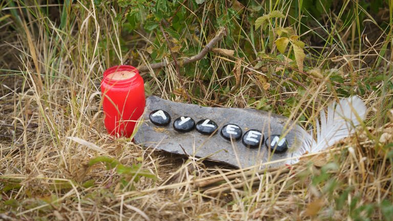 Kerze und ein Stein mit dem Namen der getöteten Ayleen