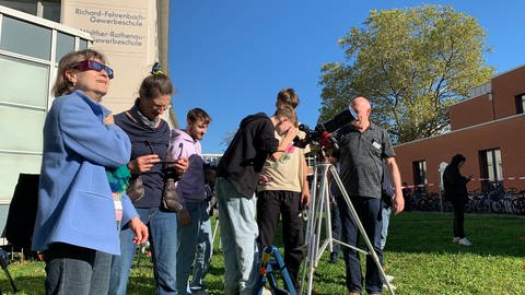 Menschen in Freiburg beobachten fasziniert die partielle Sonnenfinsternis (Foto: SWR, Silas Schwab)