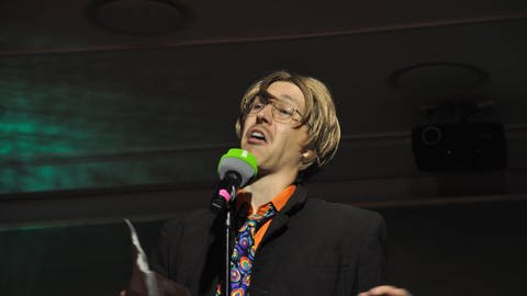 Fabian Bürklin mit orangem Hemd und bunter Krawatte  (Foto: SWR)