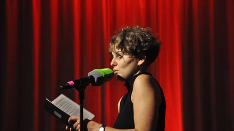 eine Frau auf der Bühne mit einem Buch in der Hand (Foto: SWR, Christoph Ebner)