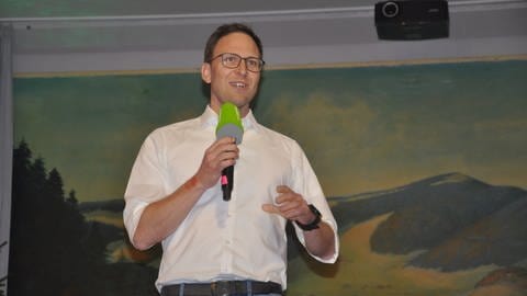 Alexander Schönemann auf einer Bühne mit Mikrofon in der Hand (Foto: SWR, Christoph Ebner)