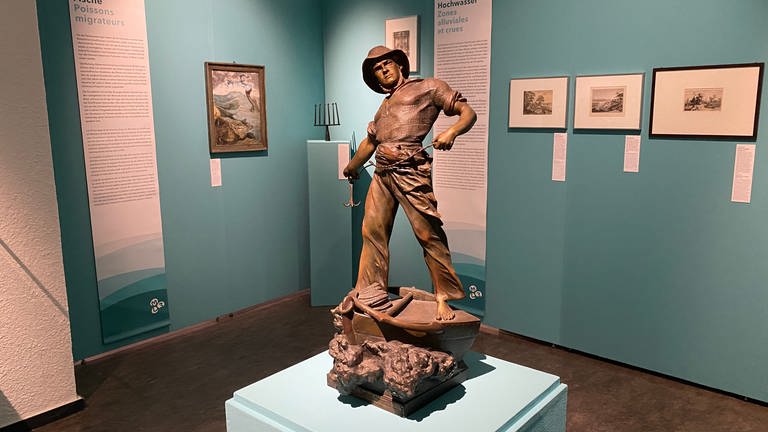 Zu sehen ist eine Skulptur aus Bronze. Es ist ein Fischer, der auf einem Boot steht, er hält eine Angelschnur in der Hand, die er dabei ist, auszuwerfen. (Foto: SWR, Katharina Seeburger)