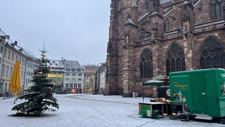 Markt vor dem Freiburger Münster ist leerer als üblich. Nur zwei Stände sind aufgebaut. Schnee liegt auf dem Boden. (Foto: SWR, Paula Zeiler)