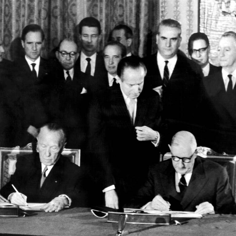 Der französische Staatspräsident Charles de Gaulle (rechts) und der deutsche Bundeskanzler Konrad Adenauer unterzeichnen am 22.01.1963 im Elysee-Palast in Paris den deutsch-französischen Freundschaftsvertrag.
