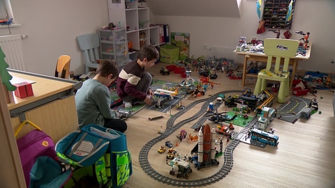 Die Zwillinge Erik und Luis spielen mit ihrer Lego-Eisenbahn.