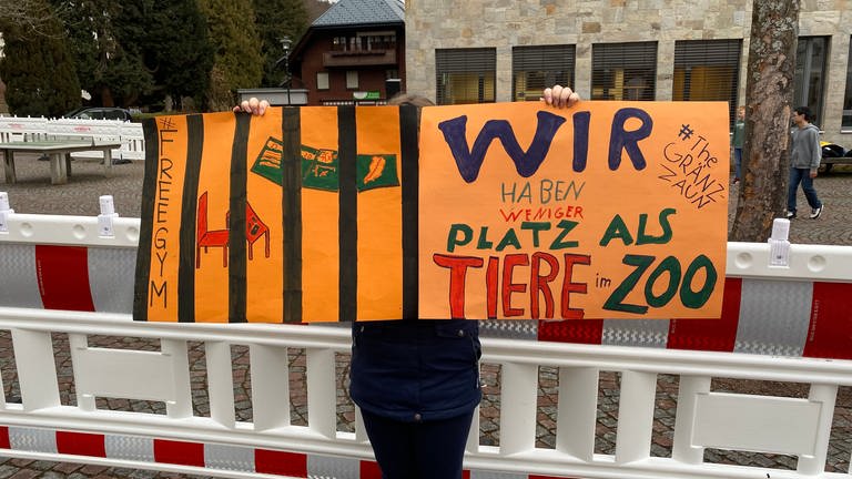 Auf einem orangenen Plakat steht: Wir haben weniger Platz als Tiere im Zoo. (Foto: SWR, Katharina Seeburger)