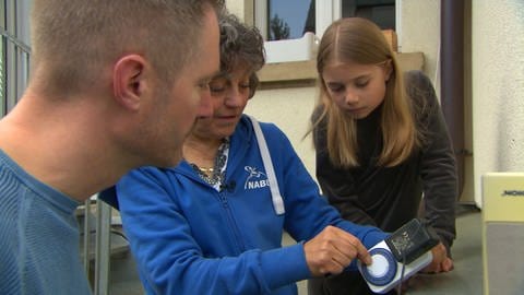 Familie Knorn baut an ihrem Haus in Freiburg eine Nisthilfe für Mehlschwalben zusammen mit Schwalbenexpertin Beate Hippchen vom NABU.