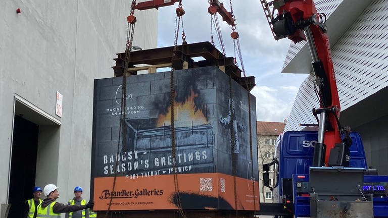 Das fast acht Tonnen schwere Banksy-Kunstwerk "Season´s Greetings" wird in Basel per Kran von einem Schwertransporter gehoben. (Foto: SWR, Matthias Zeller)