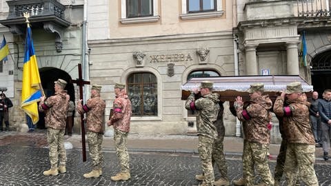 Uniformierte Soldaten, die einen Sarg tragen. (Foto: SWR)