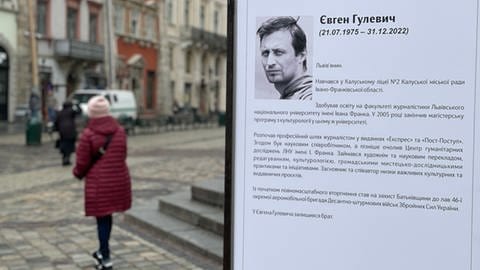 Ein Plakat mit dem schwarz-weißen Foto eines Mannes mit einem Text in kyrillischer Schrift.