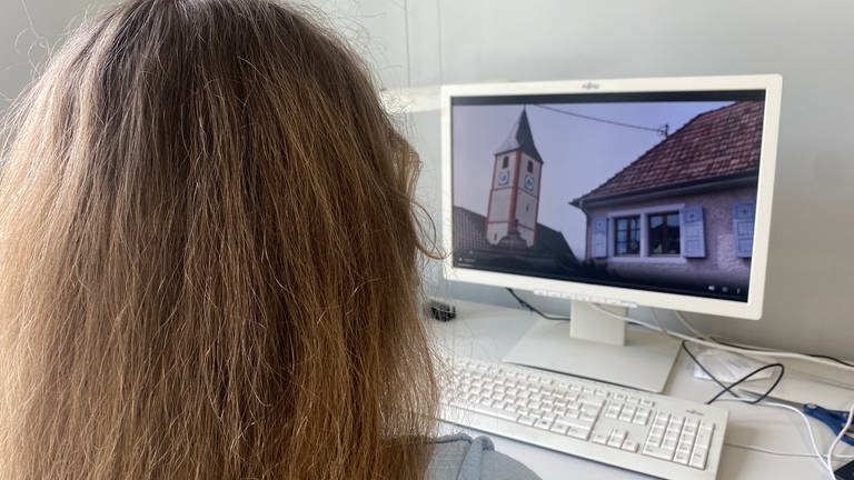 Eine Person sitzt an einem Monitor und schaut sich das Werbevideo für die Bürgermeisterwahl in Sasbach an. (Foto: SWR, Owusu Künzel)
