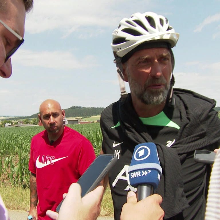 zwei Reporter und ein Mann mit Fahrradhelm (Foto: SWR, Enrico Mock )