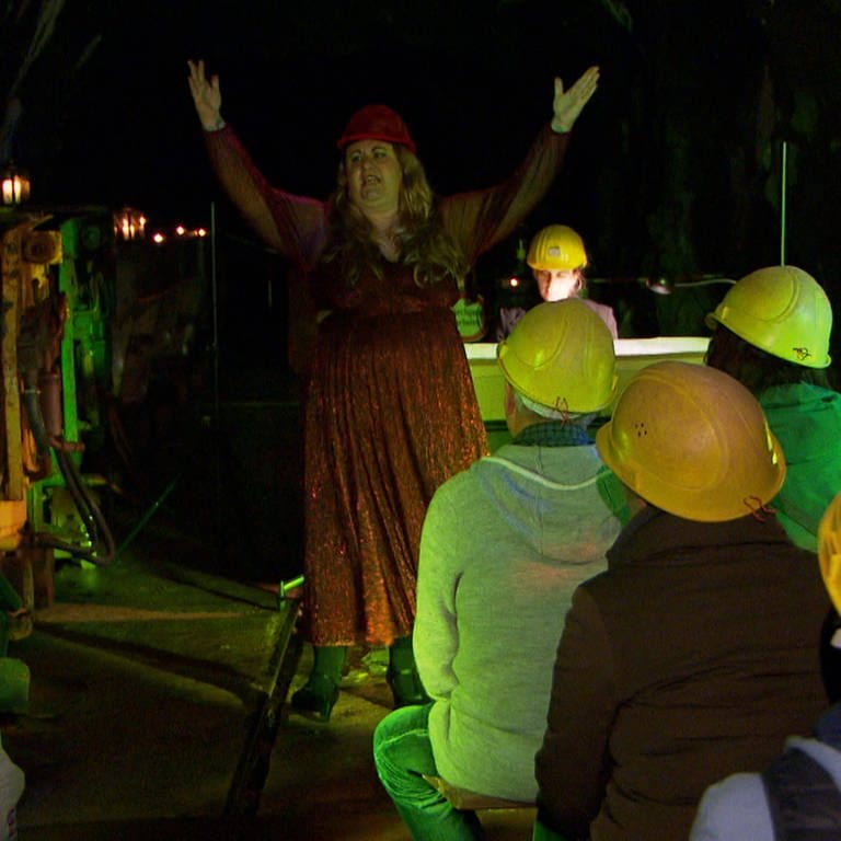 Frau singt mit offenen Armen in einem Bergwerk vor Publikum (Foto: SWR)