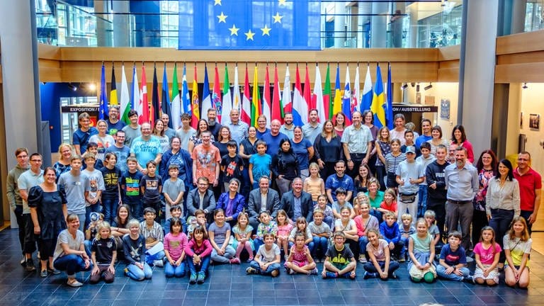 Kinder und Erwachsene posieren für ein Foto im Europäischen Parlament.