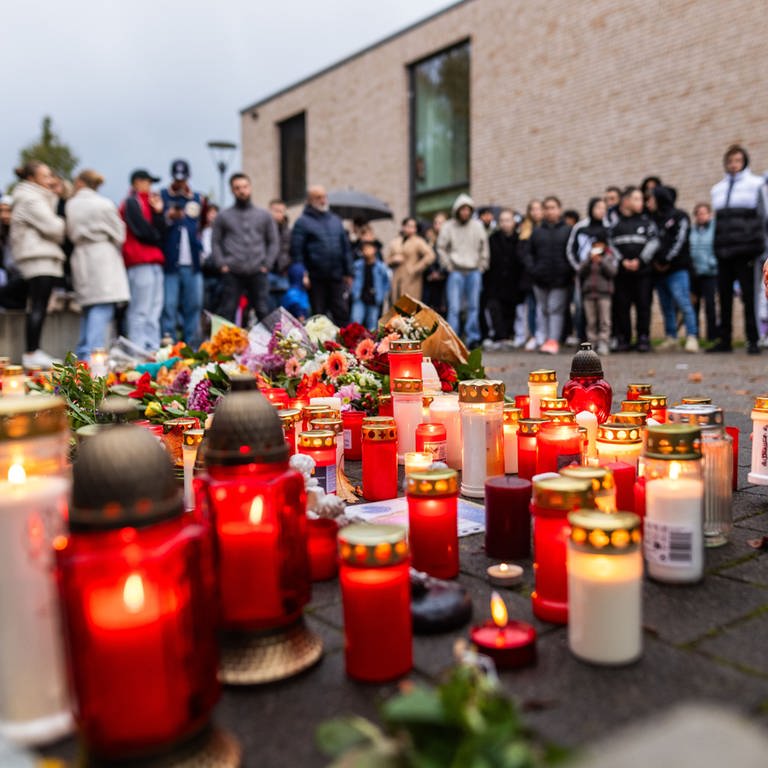Kerzen leuchten vor einer Offenburger Schule. Dort soll ein Schüler auf einen anderen Schüler geschossen und diesen tödlich verletzt haben.
