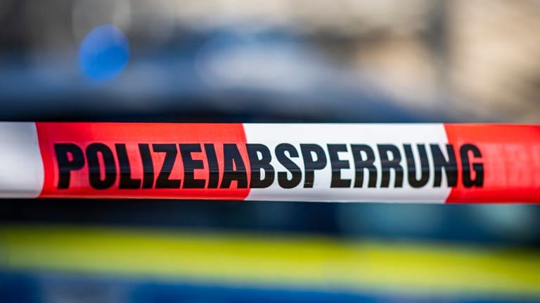 Ein Absperrband mit der Aufschrift «Polizeiabsperrung» ist vor einem Polizeiwagen aufgespannt. Die Polizei ermittelt rund um einen Brand an der Johann-Peter-Hebel-Grundschule in Teningen. 