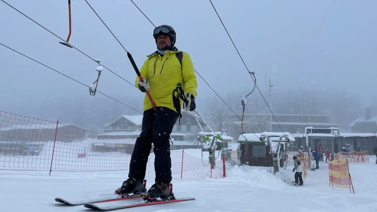 Ein Skifahrer lässt sich in einem Schlepplift eine Feldbergpiste hochziehen.  (Foto: SWR, Anita Westrup)