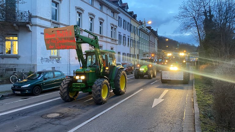 Traktoren mit Plakaten fahren durch Freiburg.