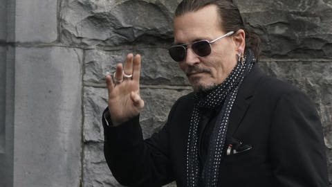 Johnny Depp winkt in die Kamera - ein Betrüger gab sich als der Schauspieler aus 