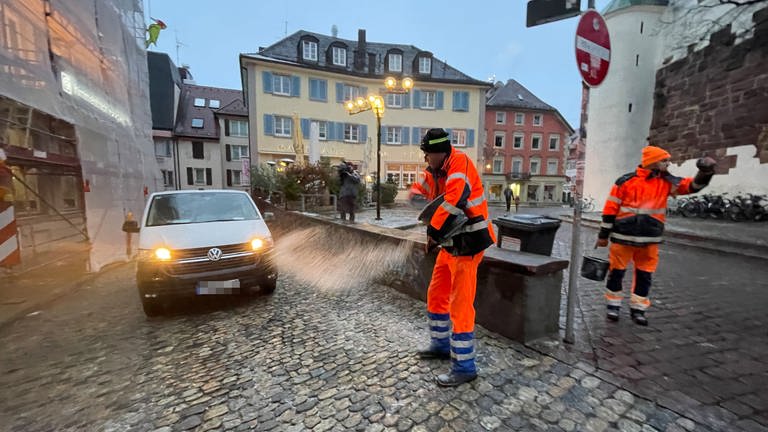 Mitarbeiter der Stadtreinigung streuen das vereiste Pflaster in der Freiburger Innenstadt (Foto: SWR, Anita Westrup)