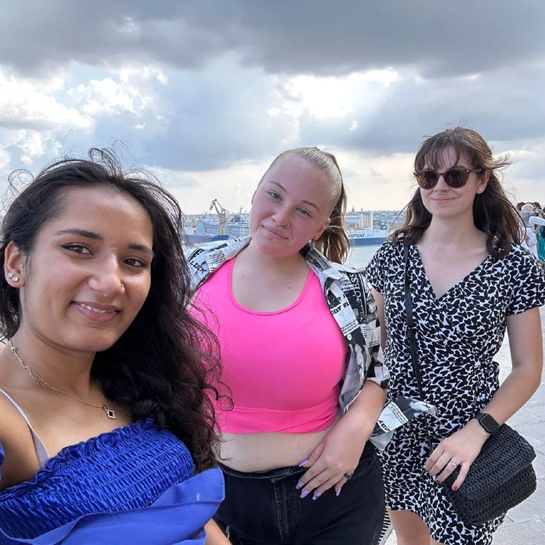 Selfie von drei junge Frauen, im Hintergrund Touristen, Wasser, Säulen