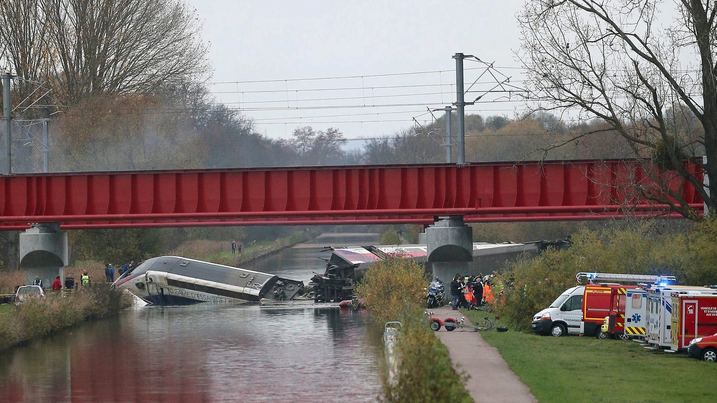 Ein Zug in einem Kanal, zerbrochen, Rettungswagen stehen vor den Brückenpfeilern (Foto: dpa Bildfunk, Jean Marc Loos)