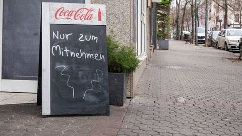 Ein Schild vor einem Restaurant, auf dem steht: Alles zum Mitnehmen.