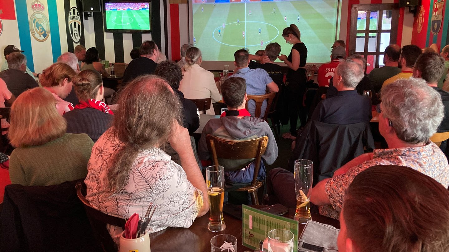 Alle schauen gespannt auf den Bildschirm: SC-Fans schauen in einer Freiburger Kneipe das letzte Spiel von Christian Streich. (Foto: SWR, Peter Steffe)