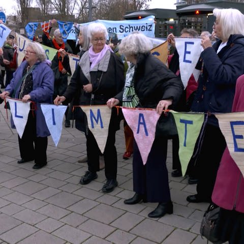 Eine Gruppe von älteren Frauen protestiert für die Einhaltung der Klimaziele.