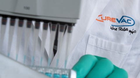 Ein Mann pipettiert in einem Labor des biopharmazeutischen Unternehmens CureVac eine blaue Flüssigkeit. (Foto: dpa Bildfunk, picture alliance/dpa | Sebastian Gollnow; Archivbild)