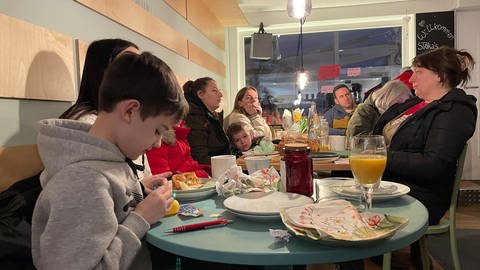 Das Bild zeigt Frauen und Kinder an einem Tisch in einem Café (Foto: SWR, Franziska Ehrenfeld)