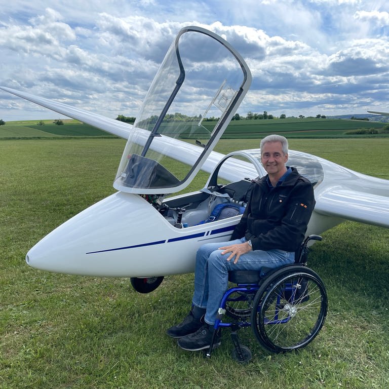 Mann im Rollstuhl neben einem Segelflieger (Foto: SWR, Anette Hübsch)