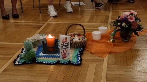 Eine Kerze steht in der Mitte eines Stuhlkreises bei einem Treffen der Elternselbsthilfegruppe für Eltern suchtkranker Kinder. (Foto: SWR, Julia Klebitz)