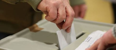 Wahlzettel beim Einwurf in die Box (Foto: dpa Bildfunk, picture alliance/dpa/Matthias Bein (Symbolbild))