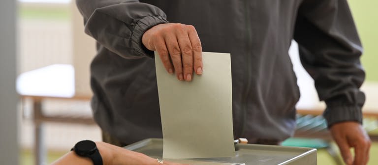 Ein Mann wirft seinen Stimmzettel in die Wahlurne. (Foto: dpa Bildfunk, picture alliance/dpa | Robert Michael)