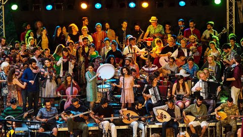 Gruppenbild Folklang 2.0 auf der Bühne. Im interkulturellen Orchester spielen bis zu 80 MusikerInnen.  (Foto: Tobias Döhner, Folklang 2.0)