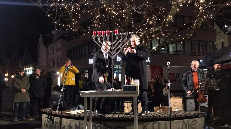 Oberbürgermeister Thomas Keck und Rabbiner Mark Mordechai Pavlovksy entzünden die Lichter bei der Chanukka-Feier auf dem Reutlinger Marktplatz (Foto: SWR, Lotta Bertz)