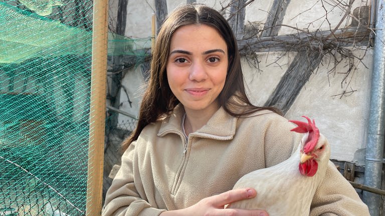 Leonore Ymeri aus Rottenburg hält ein Huhn auf dem Arm (Foto: SWR, Peter Binder)