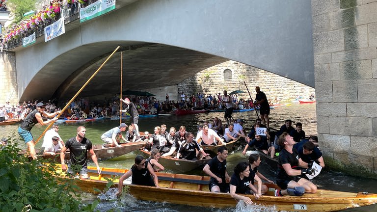 Teilnehmende des Stocherkahnrennens in Tübingen fahren mit ihren Booten über den Neckar. (Foto: SWR)