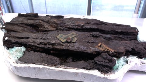 Freigelegte Funde am Keltenblock zeigt Goldbeschläge. Viele kleine solcher Blöcke untersuchen die Forscherinnen und Forscher und freuen sich, wenn sie was finden. (Foto: SWR, Rene Munder)