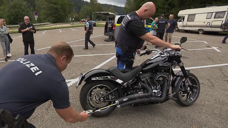 Zwei Polizisten untersuchen eine Harley Davidson (Foto: SWR)