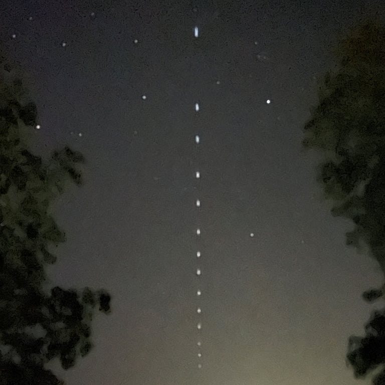 Satelliten des Unternehmens Starlink sind am Abendhimmel über Gomadingen-Marbach (Kreis Reutlingen) auf der Schwäbischen Alb zu sehen. 
