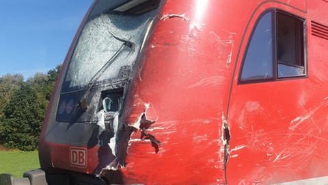 Ein roter Triebwagen der Bahn mit geplitterter Scheibe und starken Beschädigungen (Foto: privat)