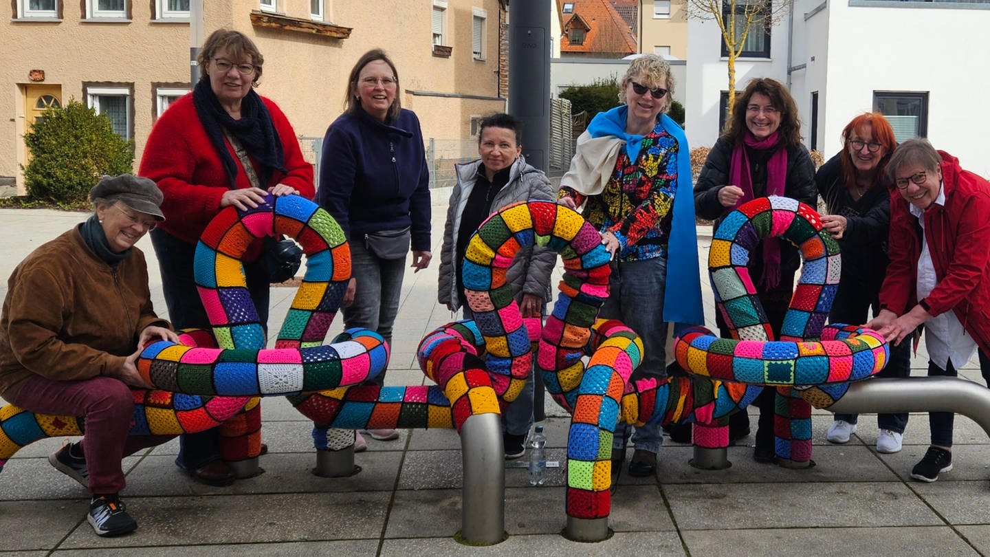 Die vielen Helferinnen präsentieren ihre mit Häkelkunst eingepackte Skulptur (Foto: Pressestelle, Birgit Krüger, blue-colour)