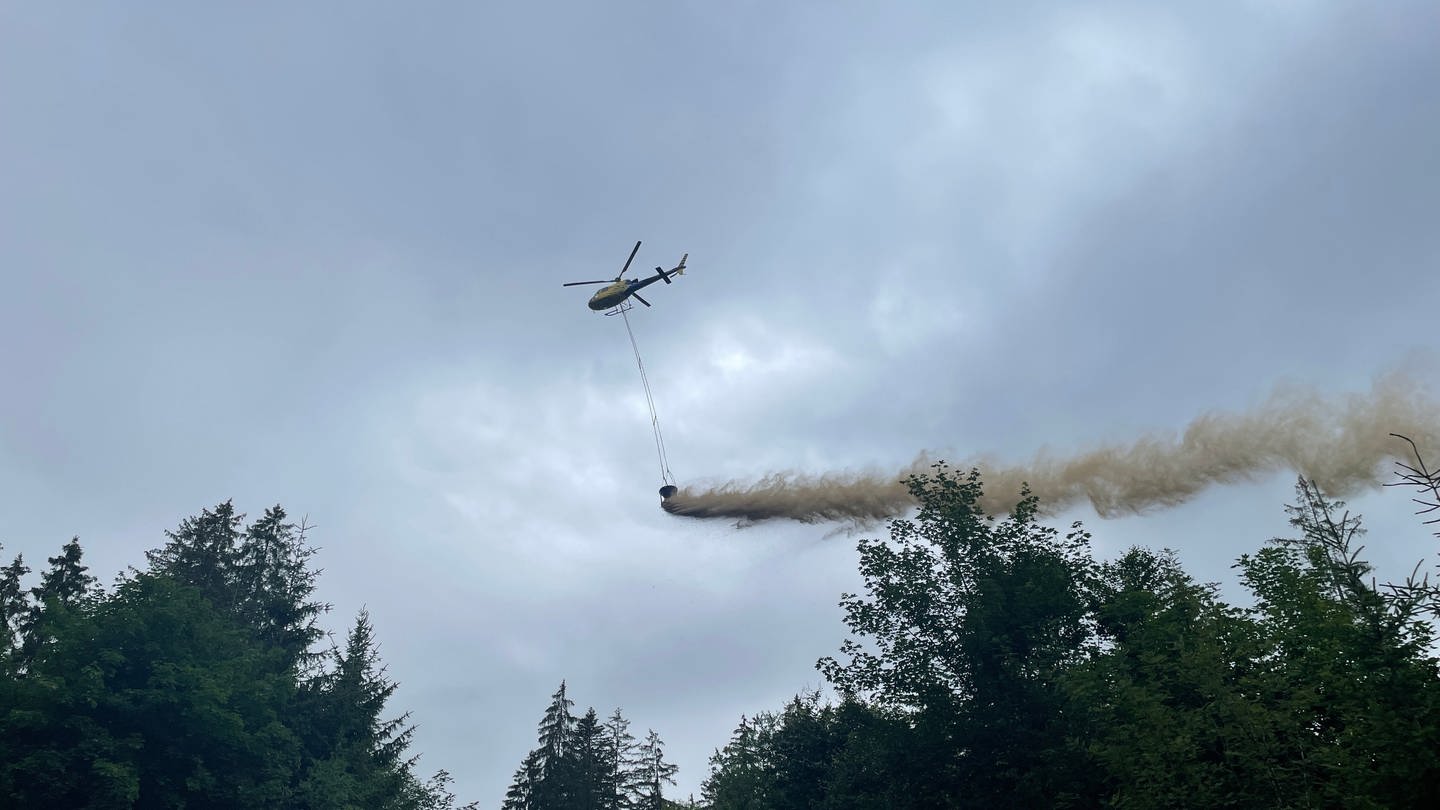 Ein Hubschrauber fliegt über den wald und verteilt Kalk (Foto: SWR, Sarah Beschorner)