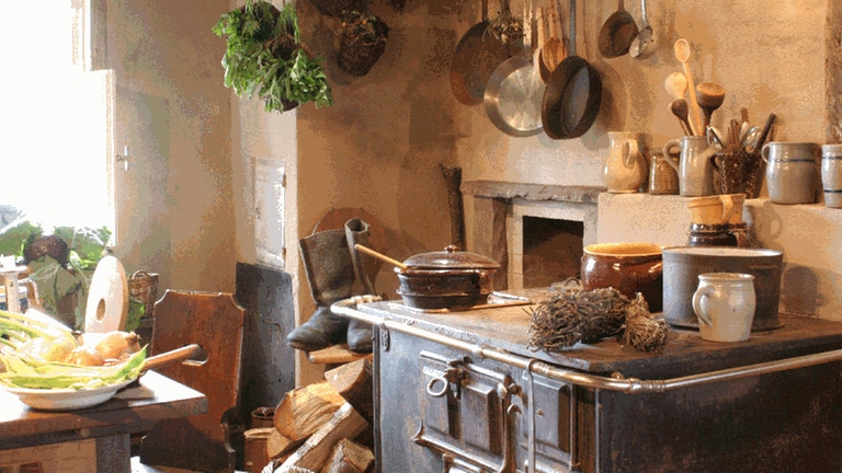 Ein alter Holzherd, frische Kräuter, Keramik und Holzlöffel in einer historischen ländlichen Küche (Foto: Pressestelle, Hotel Bareiss)