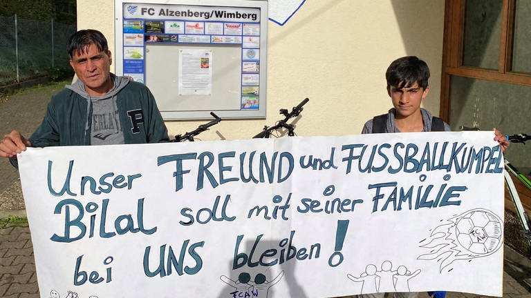 Vater und Sohn der Familie Jacobi mit Solidaritäts-Fahne (Foto: Pressestelle, AK Asyl Schömberg / Tino Bayer)