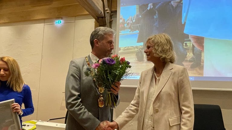 Gemeinderätin Annette Schmidt gratuliert dem Tübinger OB Boris Palmer mit einem Blumenstrauß zur 3. Amtszeit.  (Foto: SWR, Marcel Wagner)