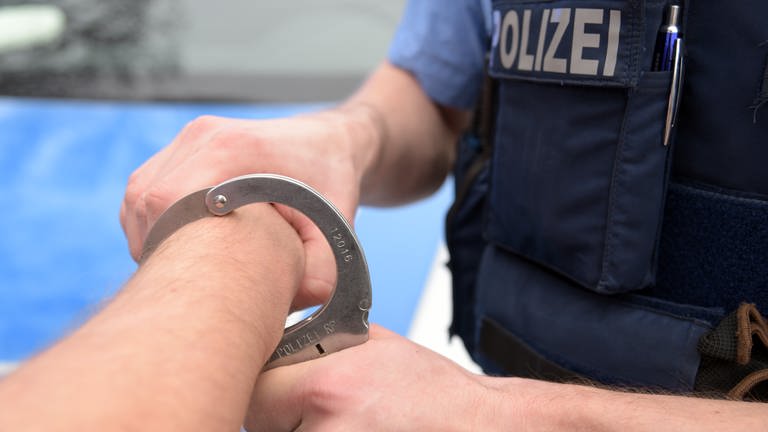 Polizist legt Handschelle an (Symbolbild) (Foto: SWR)