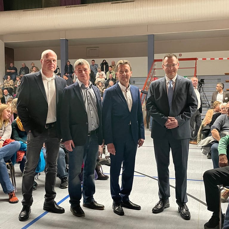 Die vier Kandidaten für die Oberbürgermeister-Wahl in Albstadt stehen inmitten des Publikums in der Zollernalbhalle